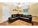 Cozy living room features a leather sectional, decorative shelves, and a bright window at 11115 Romance Ct, Winter Garden, FL 34787