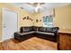 Well-lit living room with a leather sectional, hardwood floors, and a window at 11115 Romance Ct, Winter Garden, FL 34787