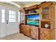 Cozy living room showcasing a wooden entertainment center and front door access at 11115 Romance Ct, Winter Garden, FL 34787
