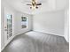 Main bedroom with neutral carpet, tray ceiling, ceiling fan, and exterior door at 120 Marion Oaks Mnr, Ocala, FL 34473