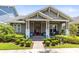 Charming home featuring manicured landscaping, covered porch, and a red front door at 13701 Chauvin Ave, Orlando, FL 32827