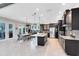 Modern kitchen with dark cabinetry, stainless appliances, and an open floor plan at 13701 Chauvin Ave, Orlando, FL 32827