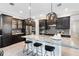 Modern kitchen featuring dark cabinetry, stainless appliances, and a marble island with seating at 13701 Chauvin Ave, Orlando, FL 32827
