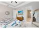 Bright bedroom featuring a TV, ceiling fan, decorative mirror, and ensuite bathroom with glass shower at 13701 Chauvin Ave, Orlando, FL 32827