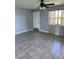 Well-lit living room showcasing gray walls, neutral tile floors, and ceiling fan at 14330 Ellerbee St, Winter Garden, FL 34787