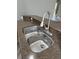 Close-up of a stainless steel kitchen sink, complemented by granite countertops and a modern faucet at 14531 Pleach St, Winter Garden, FL 34787