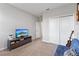 Cozy bedroom with a TV, a closet and a blue futon at 15358 Arcadia Bluff Loop, Winter Garden, FL 34787