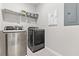 Convenient laundry room with modern, stainless steel washer and dryer, and storage shelves at 15358 Arcadia Bluff Loop, Winter Garden, FL 34787
