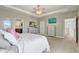 This bedroom features an ensuite bathroom, recessed ceiling, ceiling fan, and a mounted TV at 15378 Gilligan Ct, Winter Garden, FL 34787