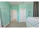 This bedroom's design features a gray carpet, light turquoise walls and two white doors, offering spacious living at 15378 Gilligan Ct, Winter Garden, FL 34787