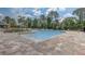 Large community pool with brick paver decking and lounge chairs on a sunny day at 15378 Gilligan Ct, Winter Garden, FL 34787