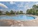Expansive community pool with a sun-drenched patio and lush tropical landscaping at 15378 Gilligan Ct, Winter Garden, FL 34787