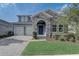 Charming home featuring stone accents, a welcoming front door, well-manicured landscaping, and a two car garage at 15378 Gilligan Ct, Winter Garden, FL 34787