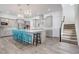 Open kitchen featuring a large center island, stainless steel appliances, stylish chandeliers, and staircase to upper level at 15378 Gilligan Ct, Winter Garden, FL 34787