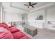 Bright living room featuring a coffered ceiling, ceiling fan and comfortable seating, shelving and a TV at 15378 Gilligan Ct, Winter Garden, FL 34787