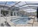Beautiful screened-in pool area with a built-in spa, water slide, and a covered lanai with ample seating at 15378 Gilligan Ct, Winter Garden, FL 34787