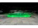 Nighttime view of the pool and spa, featuring vibrant green lighting at 15378 Gilligan Ct, Winter Garden, FL 34787