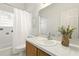 Bright bathroom with a tub, shower, tiled walls and a decorative flower arrangement at 1548 Challenger Ave, Davenport, FL 33897