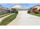 Charming home featuring a two-car garage, manicured lawn, and meticulous landscaping at 1548 Challenger Ave, Davenport, FL 33897