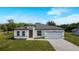 Charming single-story home with a white exterior, gray roof, paver driveway, and well-manicured lawn at 16655 Sw 43Dr Terrrace Rd, Ocala, FL 34473