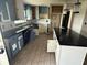 Kitchen with stylish tile flooring, an island, dark countertops and light blue and white cabinets at 1675 Louis Dr, Kissimmee, FL 34758