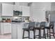 Open kitchen features a center island with seating, stainless steel appliances, and white cabinetry at 1830 Escobar Ave, Deltona, FL 32725