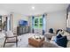 Relaxing living room featuring large windows with blue curtains, comfortable seating, and modern decor at 1830 Escobar Ave, Deltona, FL 32725