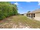 Expansive backyard showcasing screened lanai and mature trees at 2104 E Parkton Dr, Deltona, FL 32725