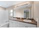 Bathroom featuring a dual sink vanity, large mirror, and step-in shower at 2104 E Parkton Dr, Deltona, FL 32725