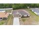 Aerial view of a well-maintained single-story home with a long driveway and lush surroundings at 2104 E Parkton Dr, Deltona, FL 32725