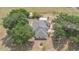 An aerial view of the home showcasing its roof, landscaping, and proximity to surrounding greenery and a circular driveway at 22619 State Road 44, Eustis, FL 32736