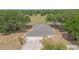 Aerial view of the home showcasing its attached garage, trees, and the circular driveway at 22619 State Road 44, Eustis, FL 32736