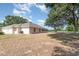 Backyard showcasing the home's exterior, A/C unit and mature trees at 22619 State Road 44, Eustis, FL 32736