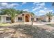 Charming single-story home with a welcoming arched entrance, stone accents, and lush landscaping at 22619 State Road 44, Eustis, FL 32736