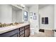 Bathroom with double sinks, vanity with dark cabinets, and a walk-in shower at 228 Bergamot Loop, Davenport, FL 33837