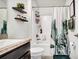 A well decorated bathroom featuring a shower and sink with floating shelves at 228 Bergamot Loop, Davenport, FL 33837