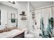 A well decorated bathroom featuring a shower and sink with floating shelves at 228 Bergamot Loop, Davenport, FL 33837