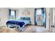 Cozy bedroom featuring two windows, tile flooring, and blue bedding at 228 Bergamot Loop, Davenport, FL 33837