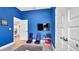This bedroom is painted blue and has two gaming chairs and a television at 228 Bergamot Loop, Davenport, FL 33837