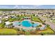 Aerial shot of the community pool, featuring a splash pad, lounge chairs and palm trees at 228 Bergamot Loop, Davenport, FL 33837
