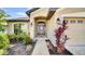 Inviting front entrance with well manicured landscaping, a black front door, and a two-car garage at 228 Bergamot Loop, Davenport, FL 33837