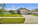 Charming single-story home with a well-manicured lawn and traditional architectural details at 228 Bergamot Loop, Davenport, FL 33837