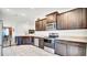 Modern kitchen with stainless steel appliances, dark wood cabinets, and tile flooring at 228 Bergamot Loop, Davenport, FL 33837