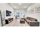 Spacious living room featuring a comfortable couch, desk and tile flooring at 228 Bergamot Loop, Davenport, FL 33837