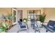 This covered patio includes furniture and various potted plants at 228 Bergamot Loop, Davenport, FL 33837
