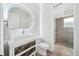 Modern bathroom with sleek vanity, unique round mirror, and a glass-enclosed shower at 2407 Lafayette Ave, Winter Park, FL 32789