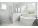 Bright bathroom featuring a modern soaking tub, glass shower, and large window with natural light at 2407 Lafayette Ave, Winter Park, FL 32789