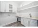 Well-lit laundry room featuring white cabinets, quartz countertop, and ample storage space at 2407 Lafayette Ave, Winter Park, FL 32789