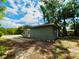 Exterior view of home with gravel driveway, and trees around the property at 2414 E Orange Ave, Eustis, FL 32726