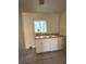 A kitchen sink with white cabinets below and a window above at 2414 E Orange Ave, Eustis, FL 32726